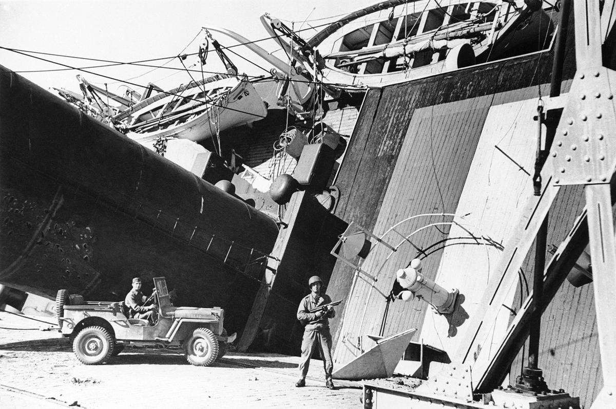 US Army sentry at the partially capsized Vichy-French ocean liner SS Porthos in the harbor at Casablanca, French Morocco, 8 Nov 1942. The Porthos was damaged by 16-inch shells fired from the USS Massachusetts.