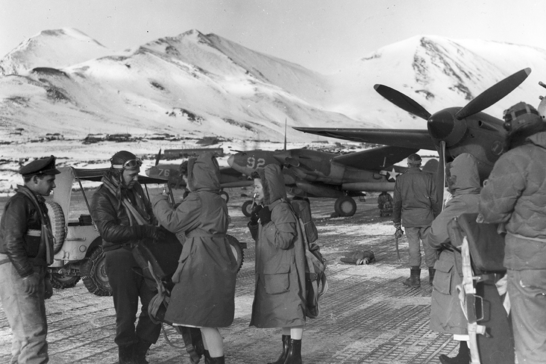 Members of the USAAF 54th Fighter Squadron with some Army nurses at Attu Island, 1943-44. Note P-38 Lightning aircraft.