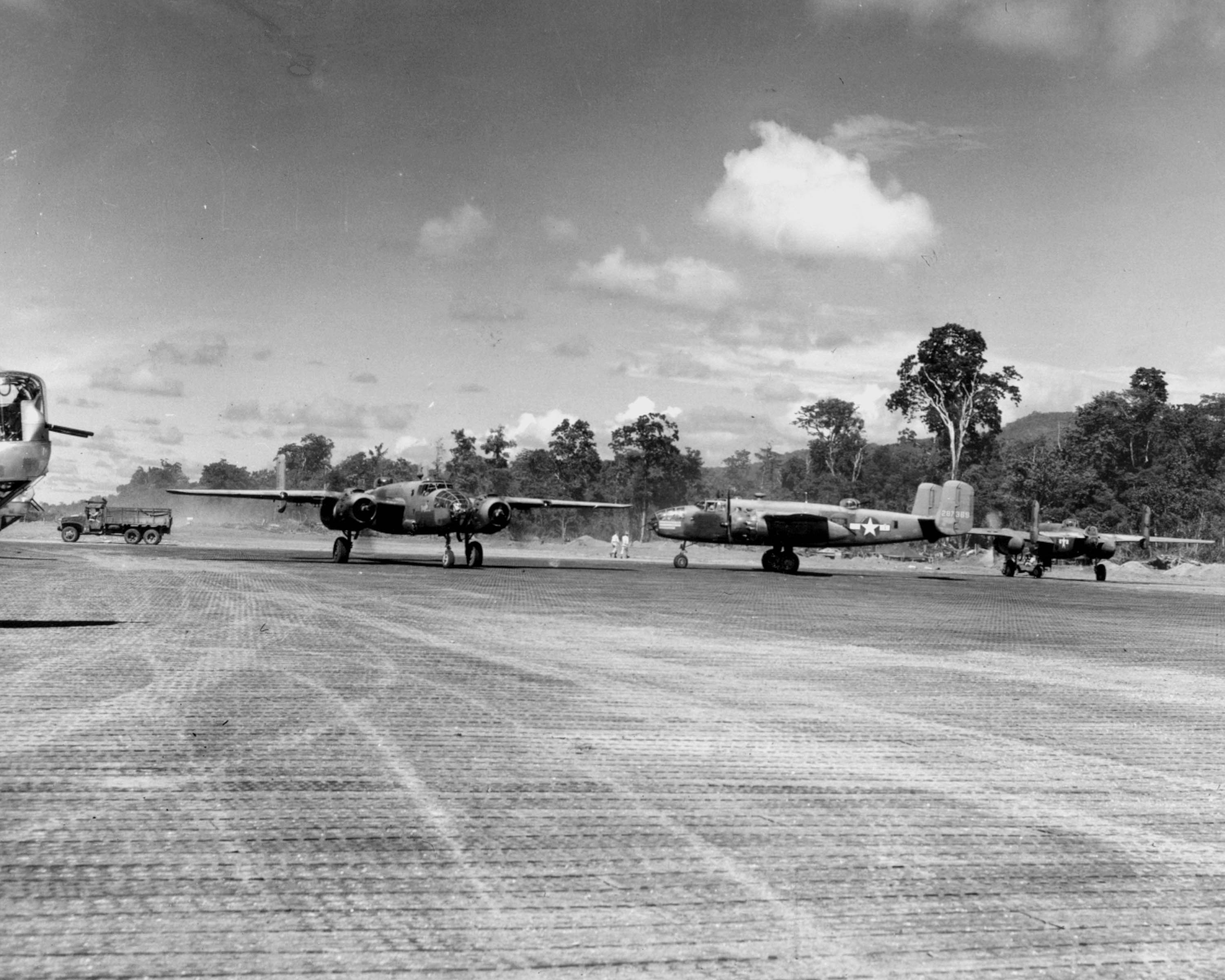 B-25 Mitchell bombers of the 42nd Bomb Group on the ramp at Munda, New Georgia, Solomons, 1943. Note B-24 Liberator nose turrets at left.