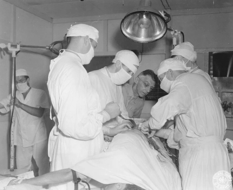 Lieutenant General Joseph Stilwell observing a surgery in progress at a base hospital in Assam, India, 15 Jul 1944