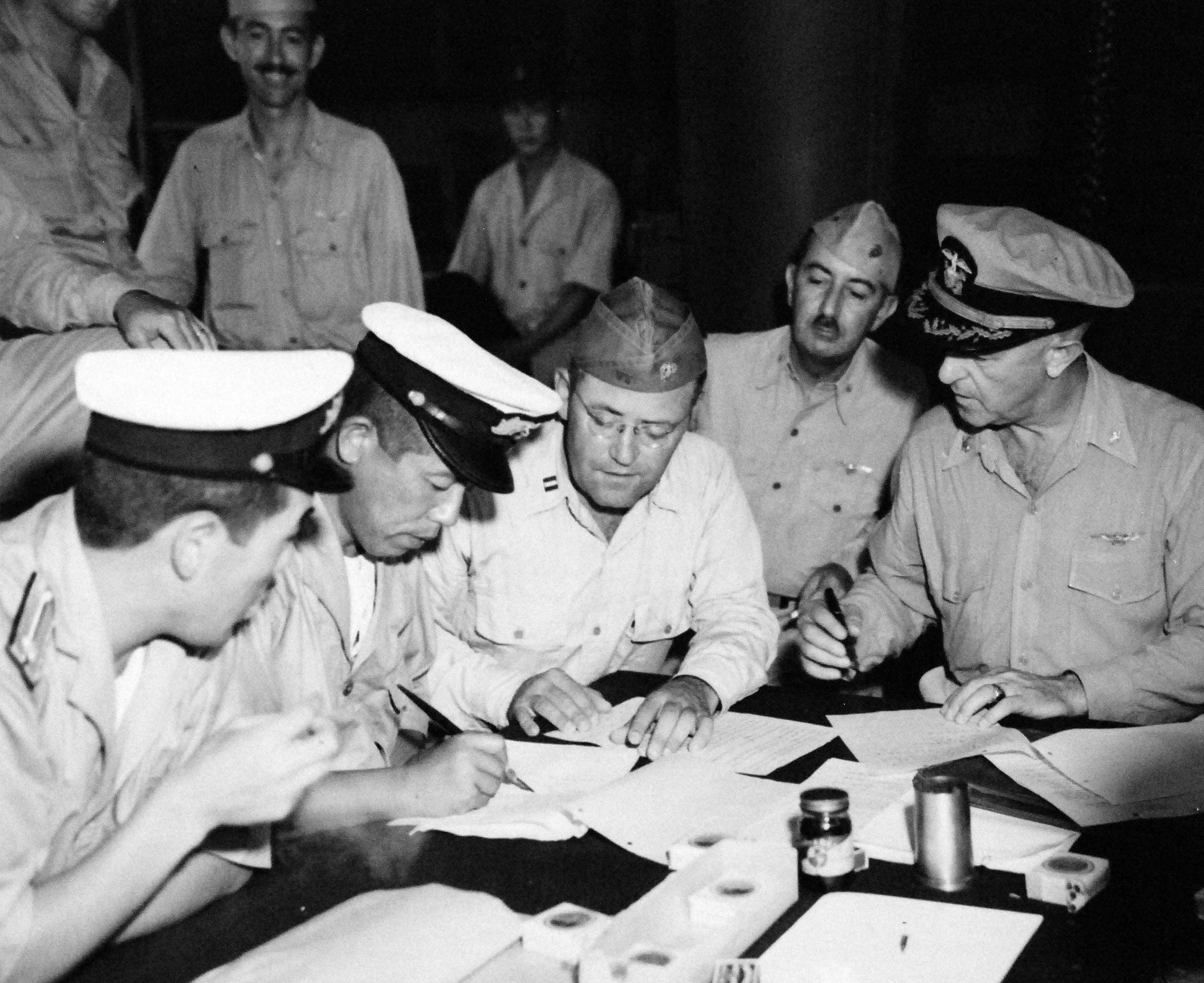 Surrender signing at Mili Atoll, Marshall Islands, aboard USS Levy, 22 Aug 1945; L to R: LtCdr Hiroshi Tokuna, Mili commander Capt Masanori Shiga, Lt ER Harris, Lt Col GV Burnett, and Majuro Area Commander Capt HB Grow
