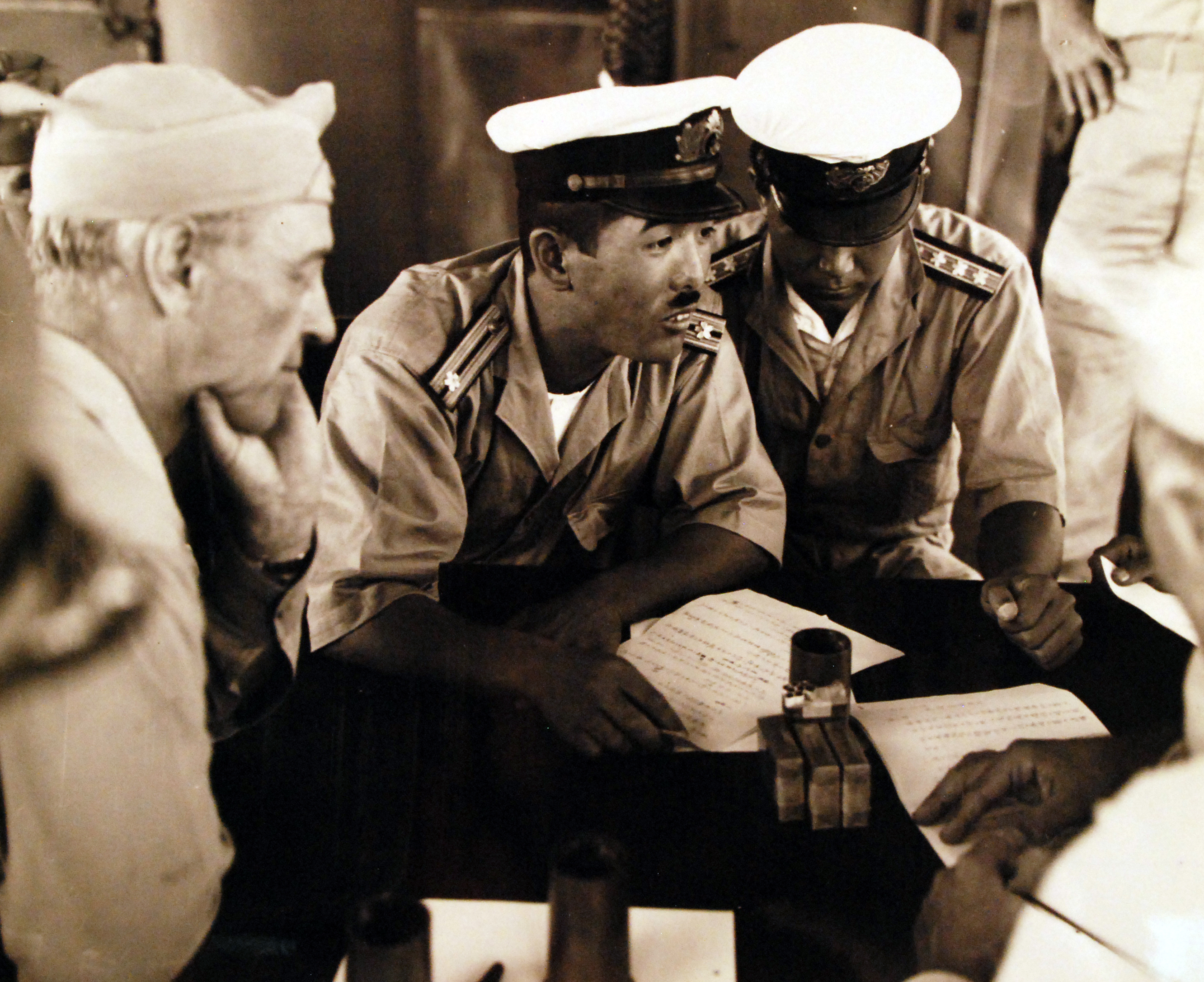 Surrender negotiations at Mili Atoll, Marshall Islands, aboard USS Levy, 19 Aug 1945; L to R: US Majuro commander Captain H. B. Grow, and Japanese representatives LtCdr Toyda and Lt Hutsu.