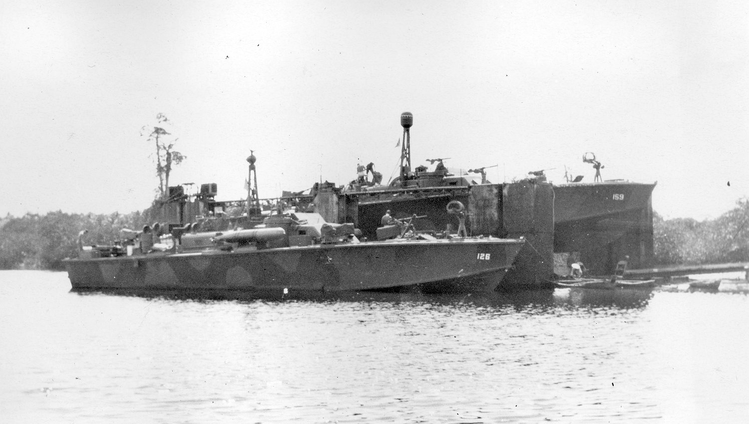 Elco 80-foot torpedo boats PT-126 and PT-159 at a floating drydock, 1944-45. Note mottled paint scheme, Mark XIII aerial torpedoes, Bofors 40mm guns aft, and 37mm cannon forward.