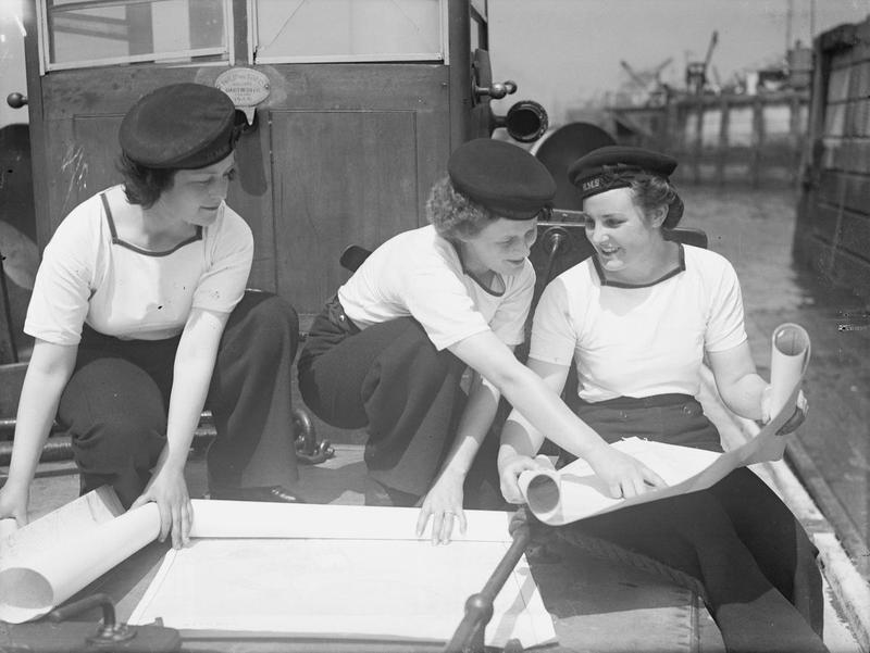 Women's Royal Naval Service river pilots Pat McGinnis, Pat Turner, and Patricia Downing studying charts at Plymouth Naval Base, England, United Kingdom, date unknown