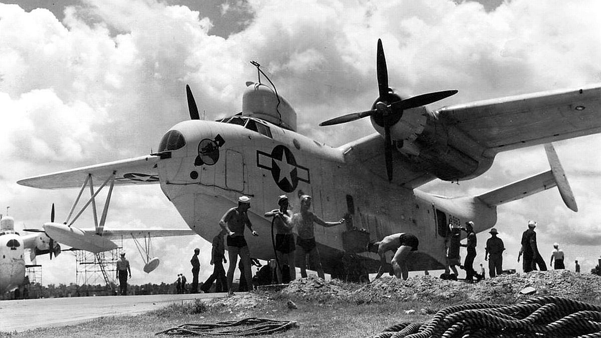United States Navy or Coast Guard beaching crews working around a PBM-5 Mariner on the ramp of an unknown seaplane base in the Atlantic area, 1944-45. Note the unusual squadron insignia on the nose.