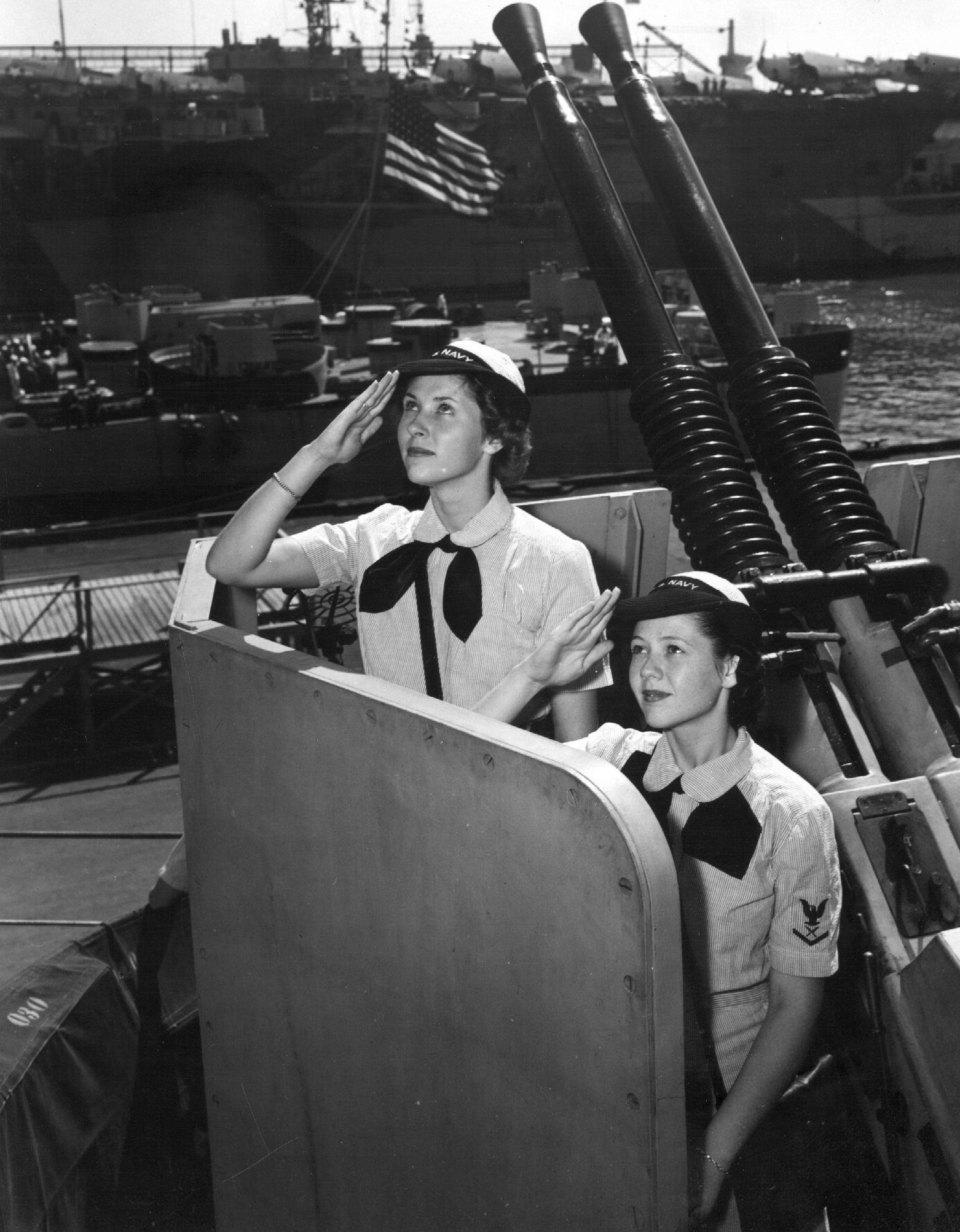 WAVES Yeoman Second Class Blanche Oswald and Yeoman Third Class Betty Martin aboard USS Missouri, Norfolk Navy Yard, Virginia, United States, 19 Aug 1944. Note USS Alaska and escort carrier USS Croatan.