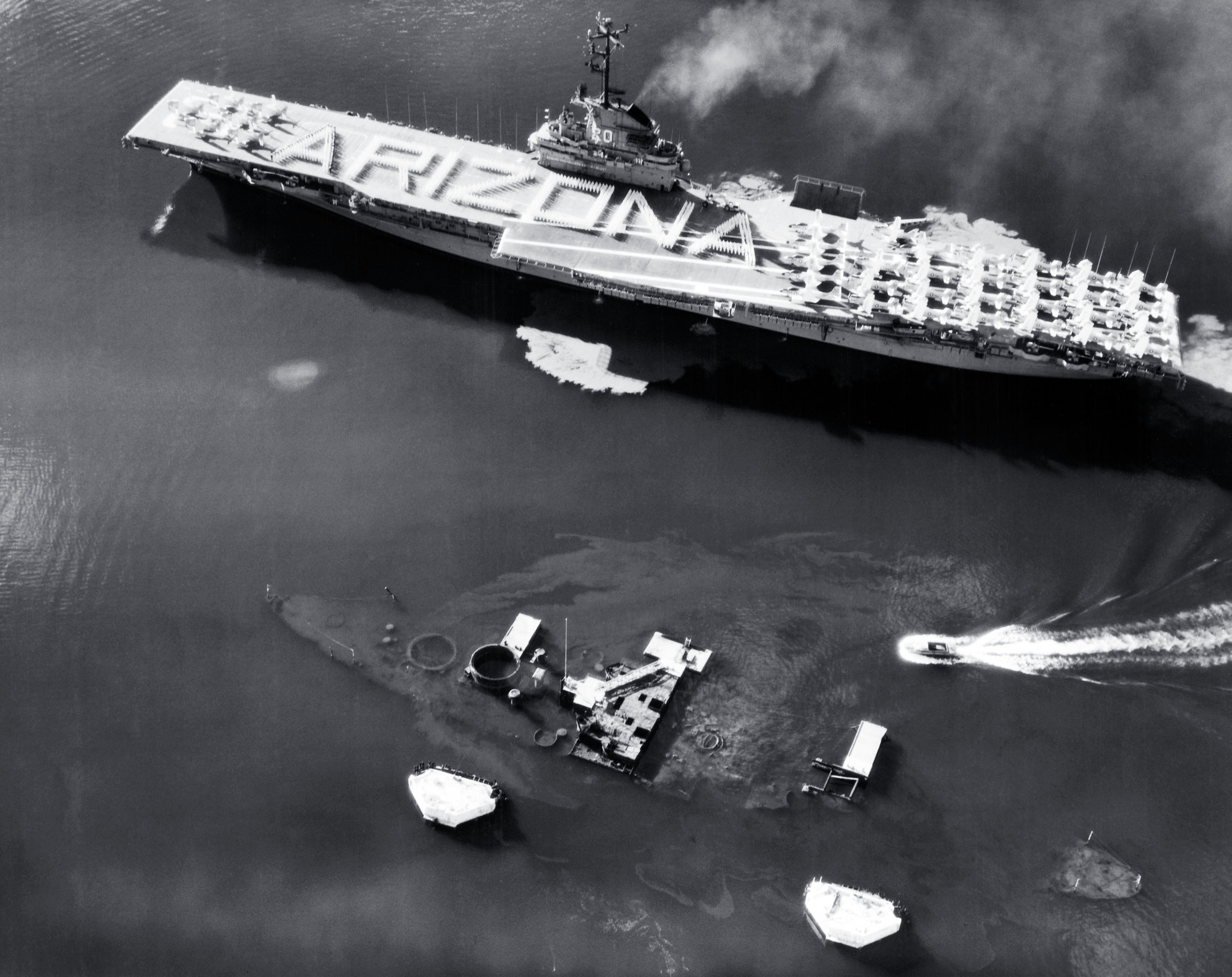 Crew of the USS Bennington honoring the sunken USS Arizona as she passes in Pearl Harbor, Hawaii, 31 May 1958. Note that Bennington now has an angled flight deck and a starboard side deck edge aircraft elevator.