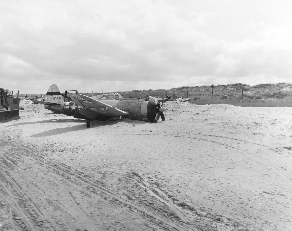 Razorback P-47D Thunderbolt of the 373rd Fighter Group after skidding to a stop on the sand of a Normandy beach, France, 14 Jun 1944.