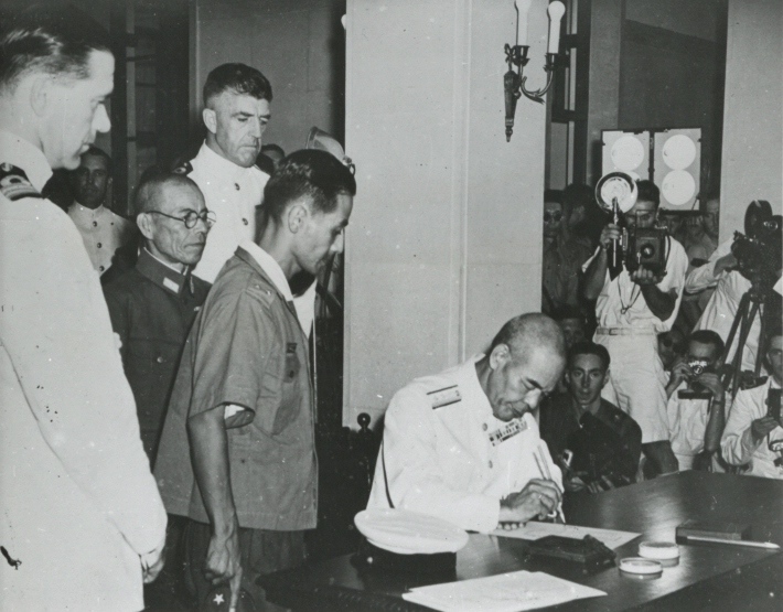 Japanese Navy Vice Admiral Ruitaro Fujita signing the Instrument of Surrender of Japanese forces in and around Hong Kong, Government House, Hong Kong, 16 Sep 1945