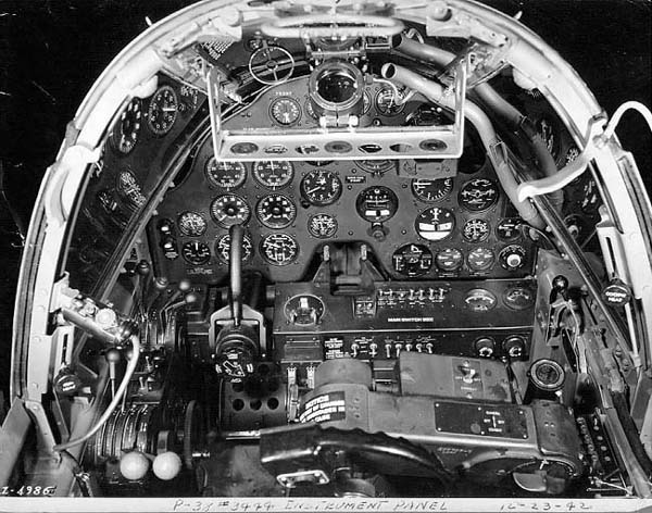 Photo] Close-up view of a P-38G Lightning aircraft cockpit, 23 Dec 1942;  note the yoke rather than stick control and the bullet proof glass panel  above the instrument panel. Photo 2 of