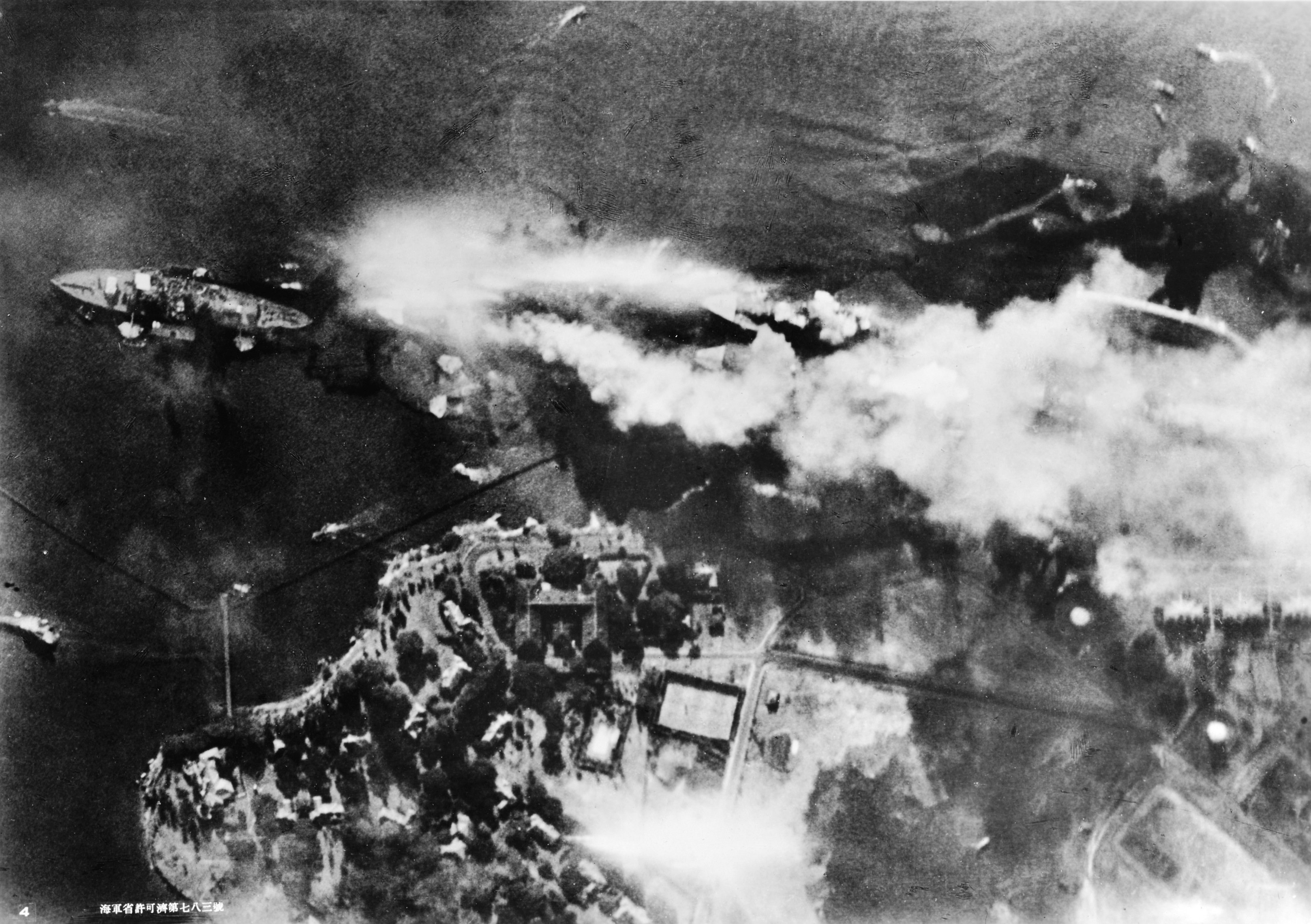 Vertical view photographed from a Japanese aircraft of Pearl Harbor’s Battleship Row soon after USS Arizona’s forward magazines exploded, 7 Dec 1941. Note capsized USS Oklahoma