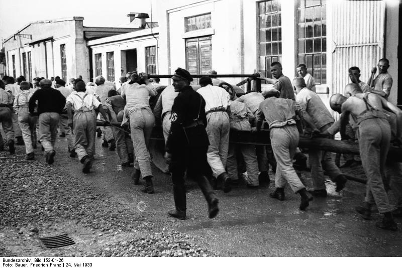Prisoners moving a heavy wagon, Dachau Concentration Camp, Germany, 24 May 1933