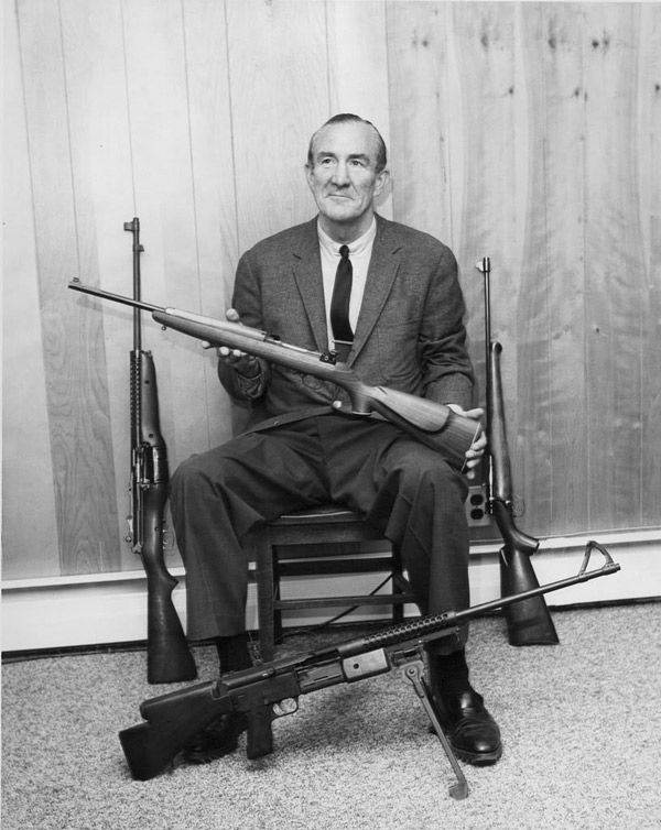 Melvin Johnson with various weapons produced by his company, 1940s