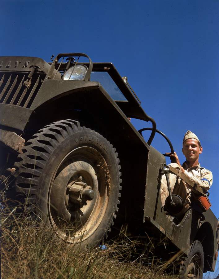 US Soldier in a Willys MA Jeep, United States, 1941. Note the fender-mounted headlamp of the MA rather than the more familiar behind the grille mount of the MB. Note also the soldier’s blue armband from a war game.