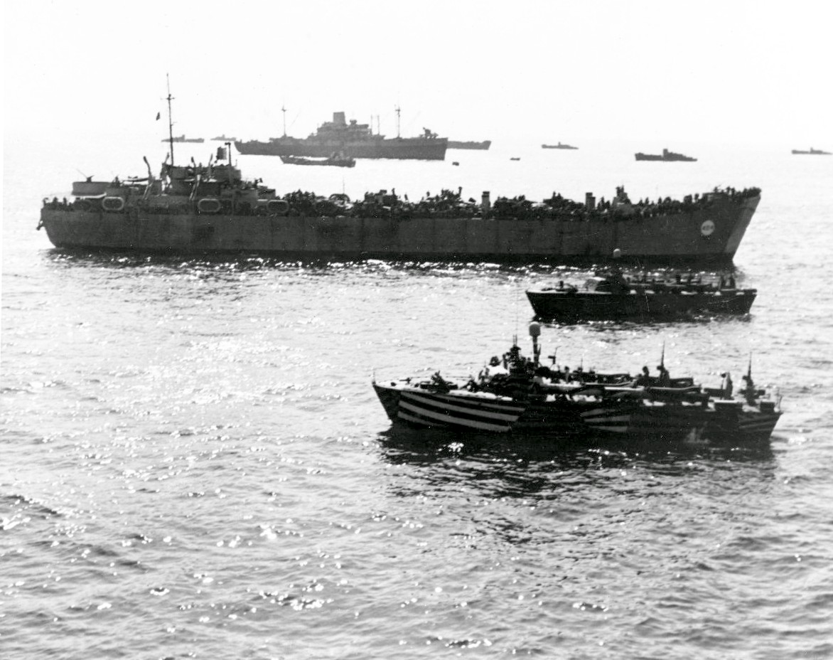 USS Ancon (background), HM LST-404, and other ships off Salerno, Italy, 12 Sep 1943