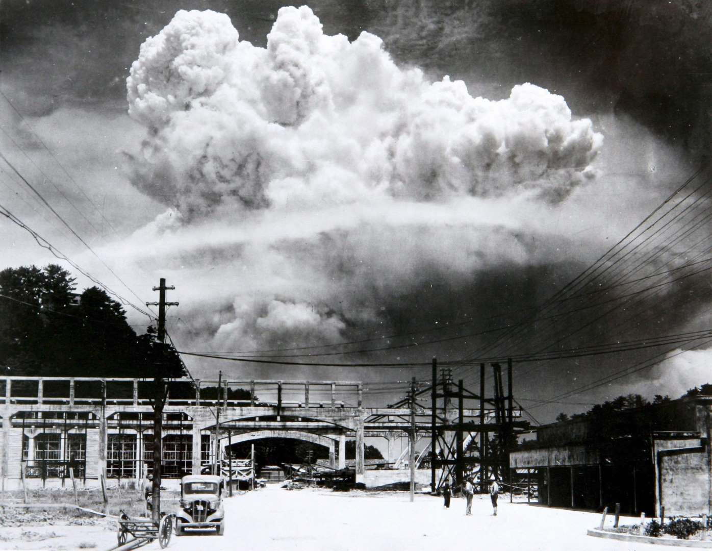Growing mushroom cloud from the atomic bomb detonation in Nagasaki, Japan, 9 Aug 1945. Note the approaching shock wave that the soldiers in the foreground are apparently not yet aware of.