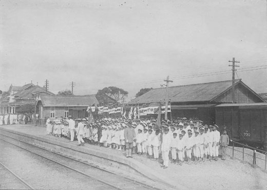 Civilians gathering to wave to Crown Prince Hirohito, who would be passing by aboard a train, Toen Rail Yard, Taiwan, 19 Apr 1923