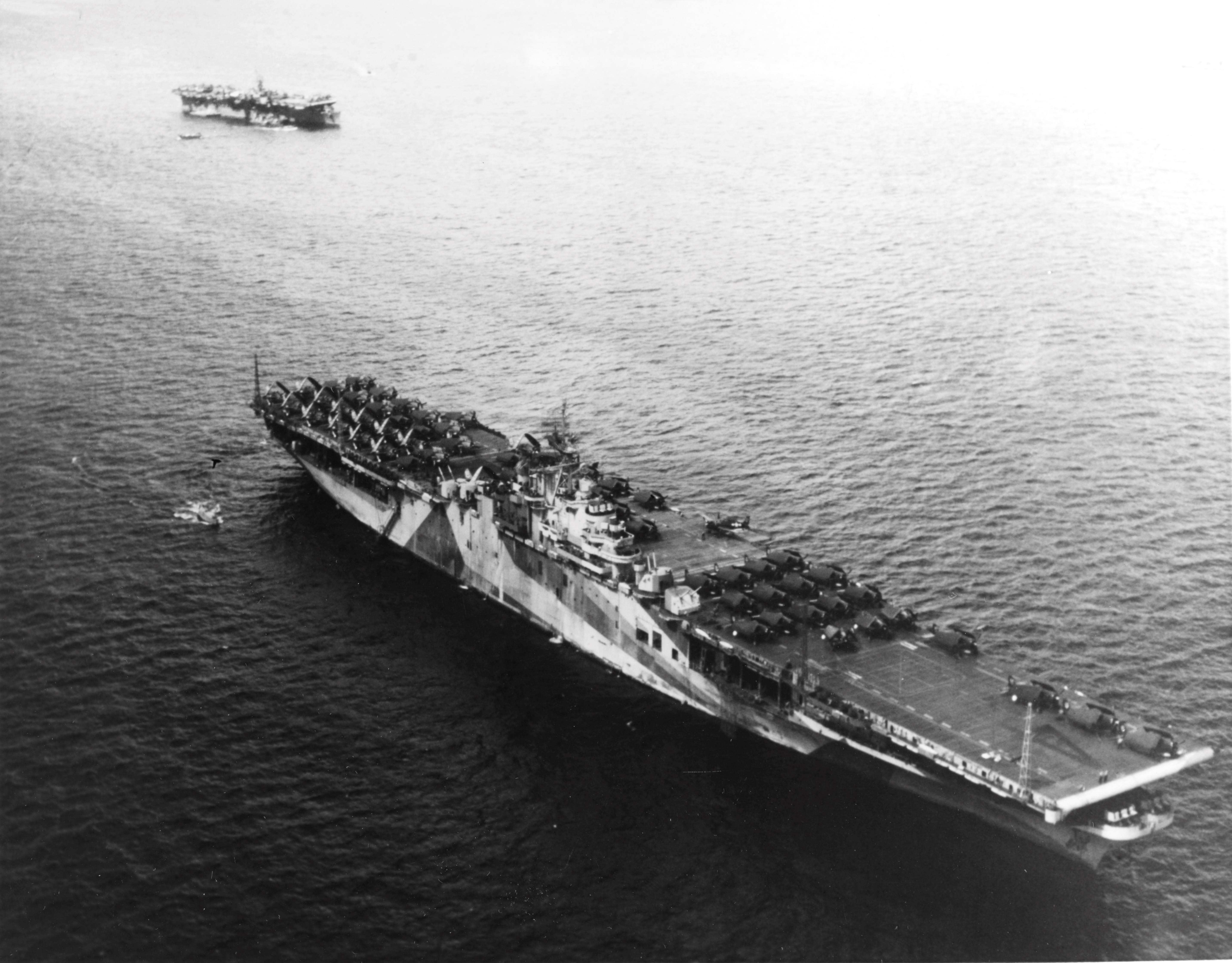 Carrier USS Ticonderoga at anchor in Ulithi Lagoon 8 Dec 1944 with USS Langley (Independence-class) beyond. Note the faded Ms33/10A paint scheme. Ticonderoga’s flight deck is loaded with the planes of Air Group 80.