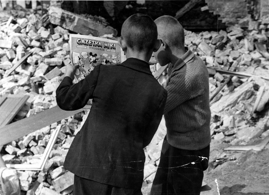 Polish boys reading Mickey Mouse comics in ruins, Warsaw, Poland, Sep 1939