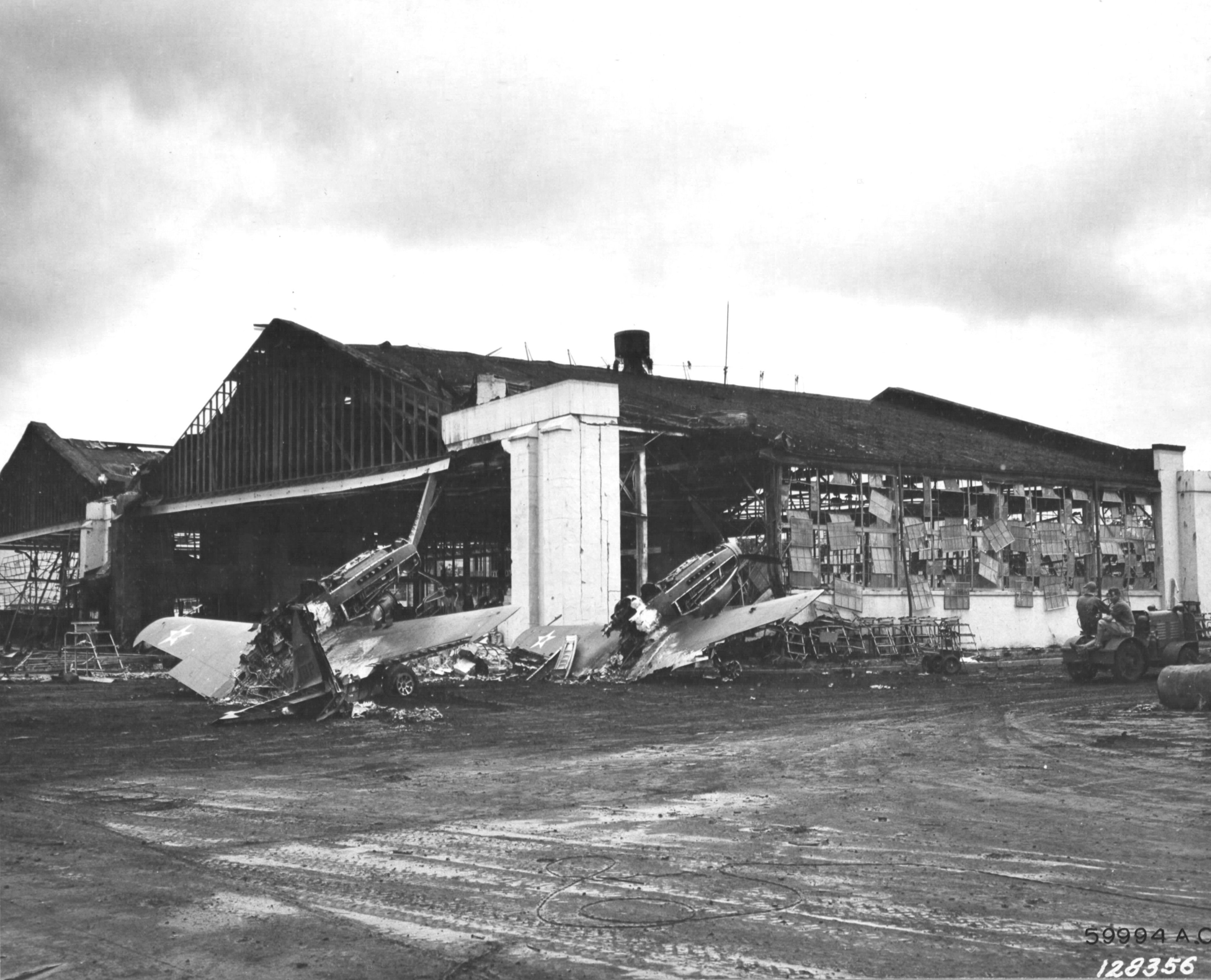 Wrecked P-40 fighters in front of the damaged Hangar #3 at Wheeler Field, Oahu, Hawaii following the Japanese Pearl Harbor attack. 11 Dec 1941 photo.
