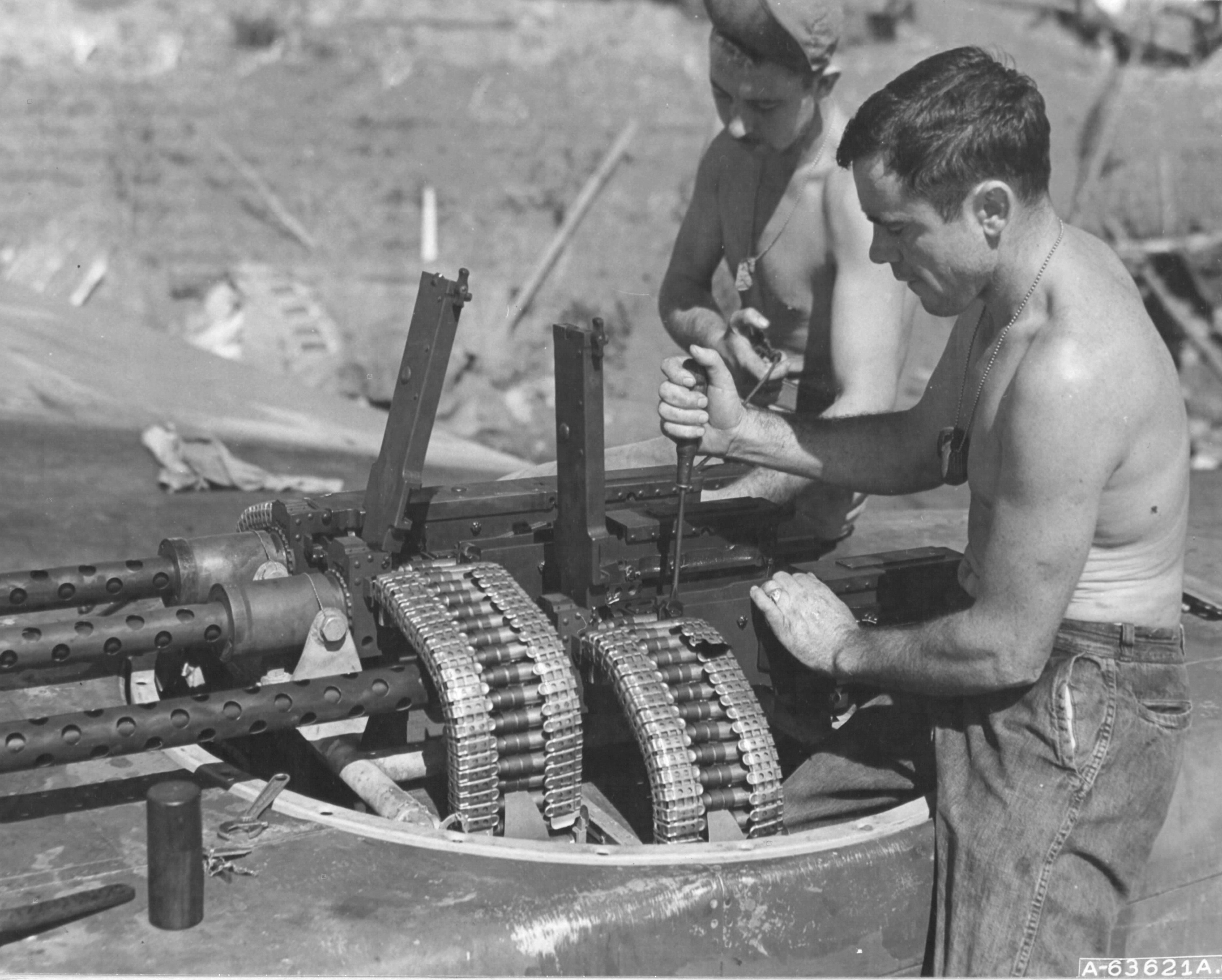 Armorers SSgt George Townsend and Sgt George Barker make ready the dorsal quad Browning .50 caliber machine guns of a P-61 Black Widow night fighter, Saipan, 19 Jul 1944.