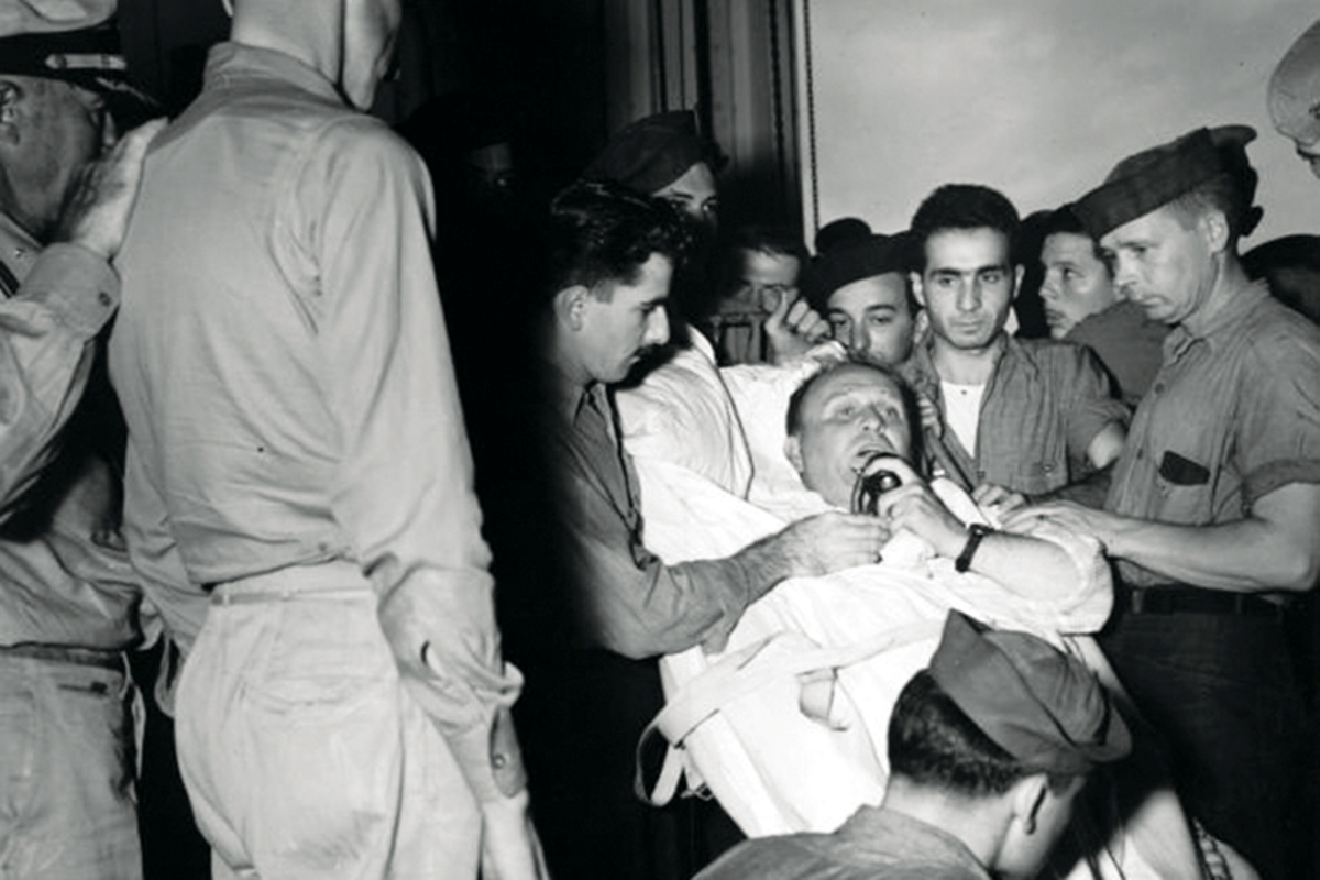 Captain Dixie Kiefer, badly injured in an air attack four days earlier, addressing his crew one more time before being transferred from USS Ticonderoga to the hospital ship Samaritan at Ulithi, 25 Jan 1945.