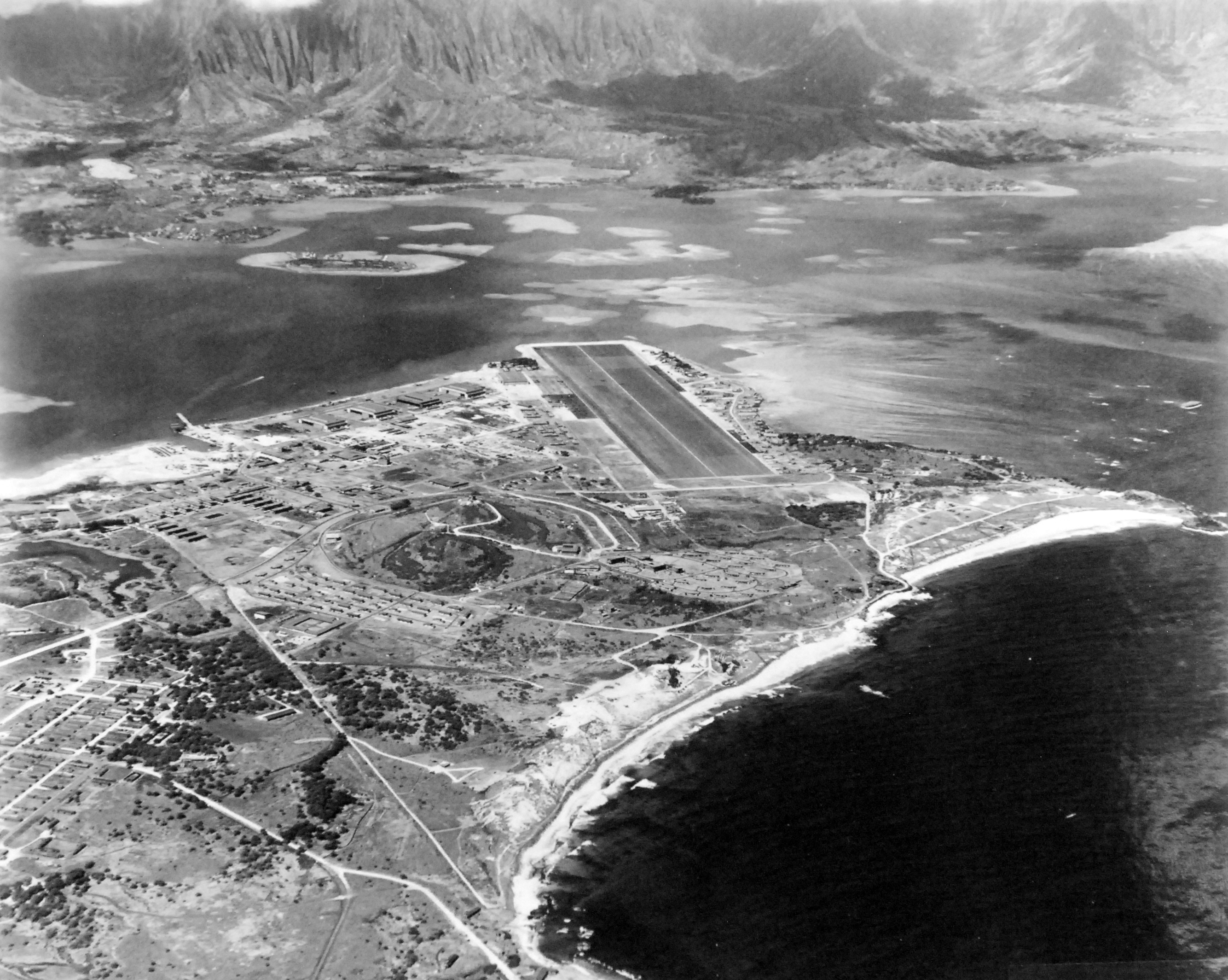 Aerial view of Naval Air Station Kaneohe, Oahu, Hawaii with Kaneohe Bay seen beyond the airstrip, Jun 1944.