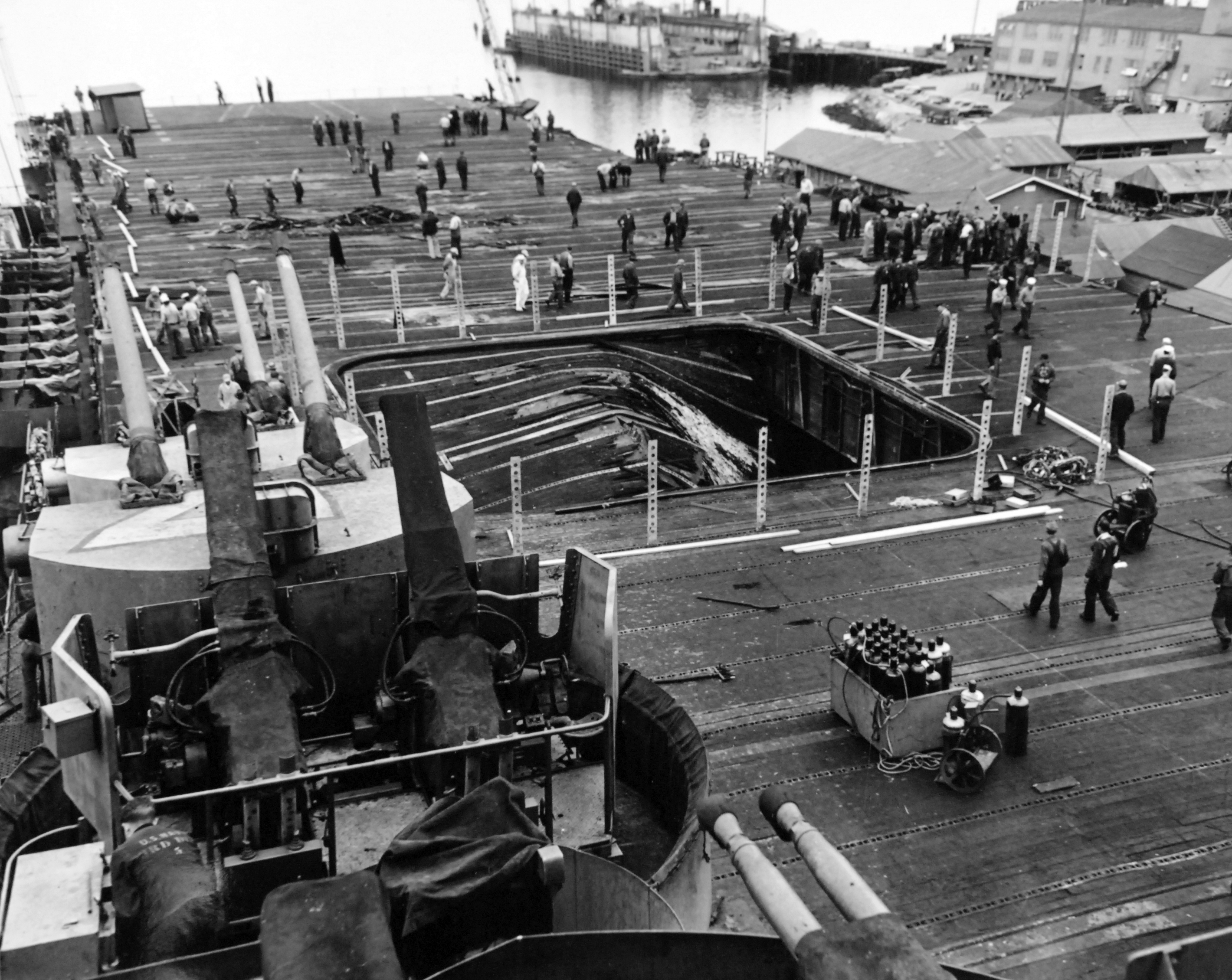 The after-flight deck of the USS Bunker Hill in Puget Sound Naval Shipyard’s Dry Dock No. 5 shortly after arriving at Bremerton, Washington, United States, 16 Jun 1945. Note the collapsed aircraft elevator.