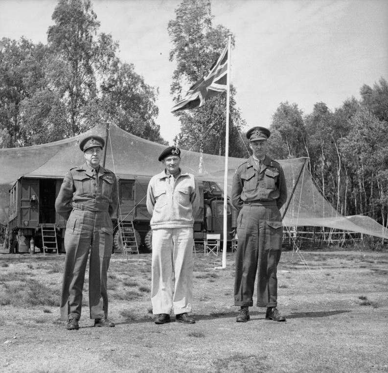 Generals Henry (Harry) Crerar and Miles Dempsey flank Field Marshal Bernard Montgomery at Montgomery’s headquarters at Lüneburg Heath, Germany, 10 May 1945.
