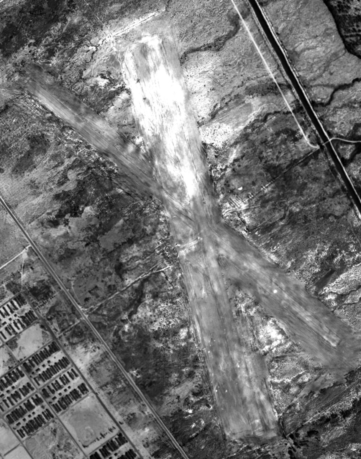 Aerial view of the Manzanar Airstrip, Inyo County, California, United States showing a portion of the Manzanar Relocation Center across the highway, 1 Oct 1944.