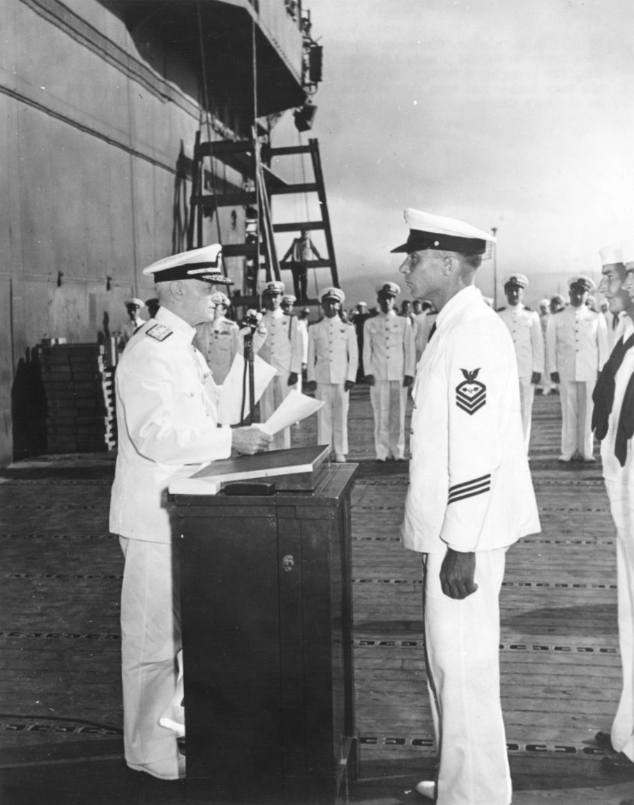 Admiral Chester Nimitz presenting the Navy Cross to Aviation Chief Machinist's Mate Harold F. Dixon aboard USS Enterprise at Pearl Harbor, Hawaii, Mar 1942.