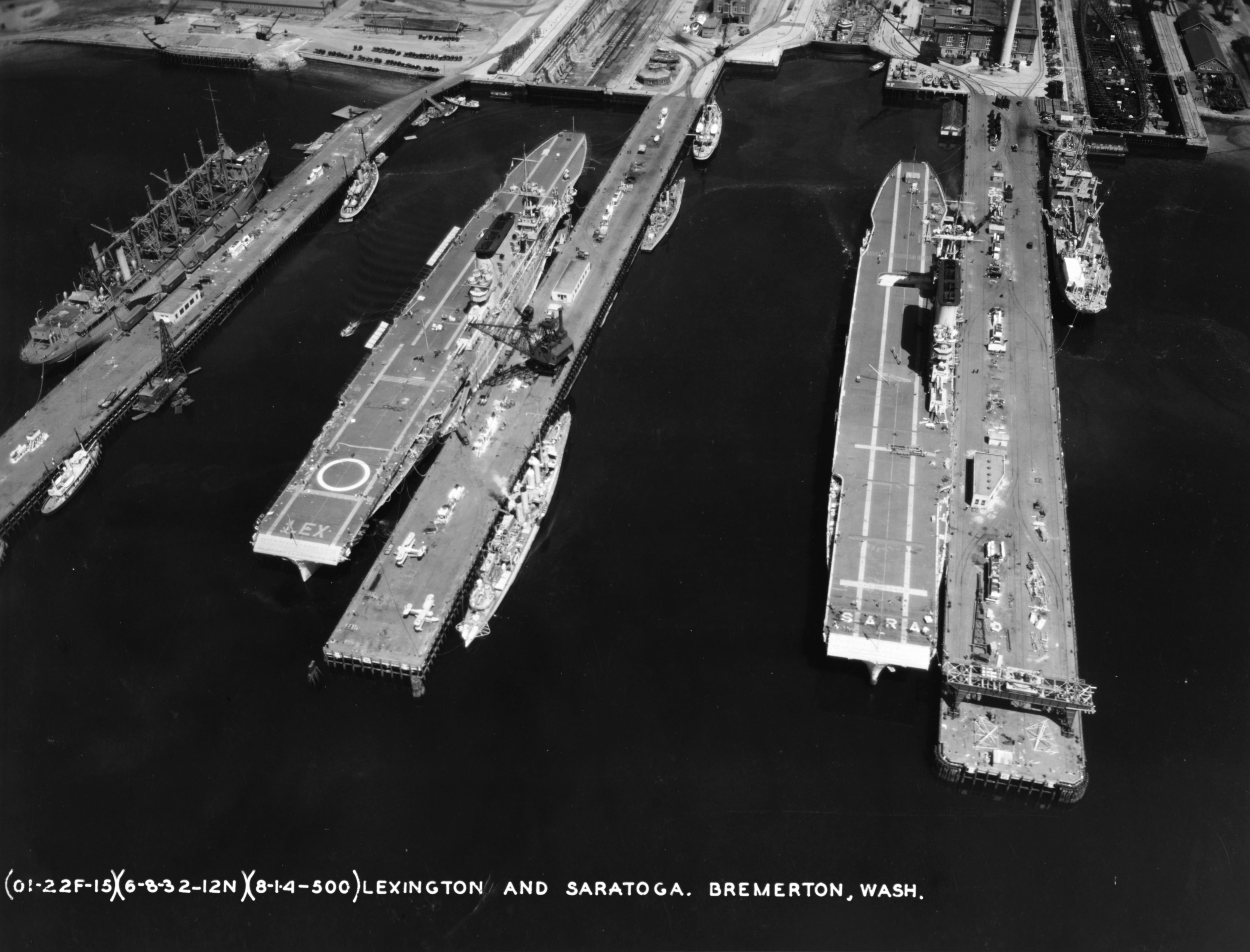 Piers at Puget Sound Navy Yard in Bremerton, Washington, United States with, left to right, repair ship (converted collier) Jason, and carriers Lexington (Lexington-class), Saratoga, 6 Aug 1932.