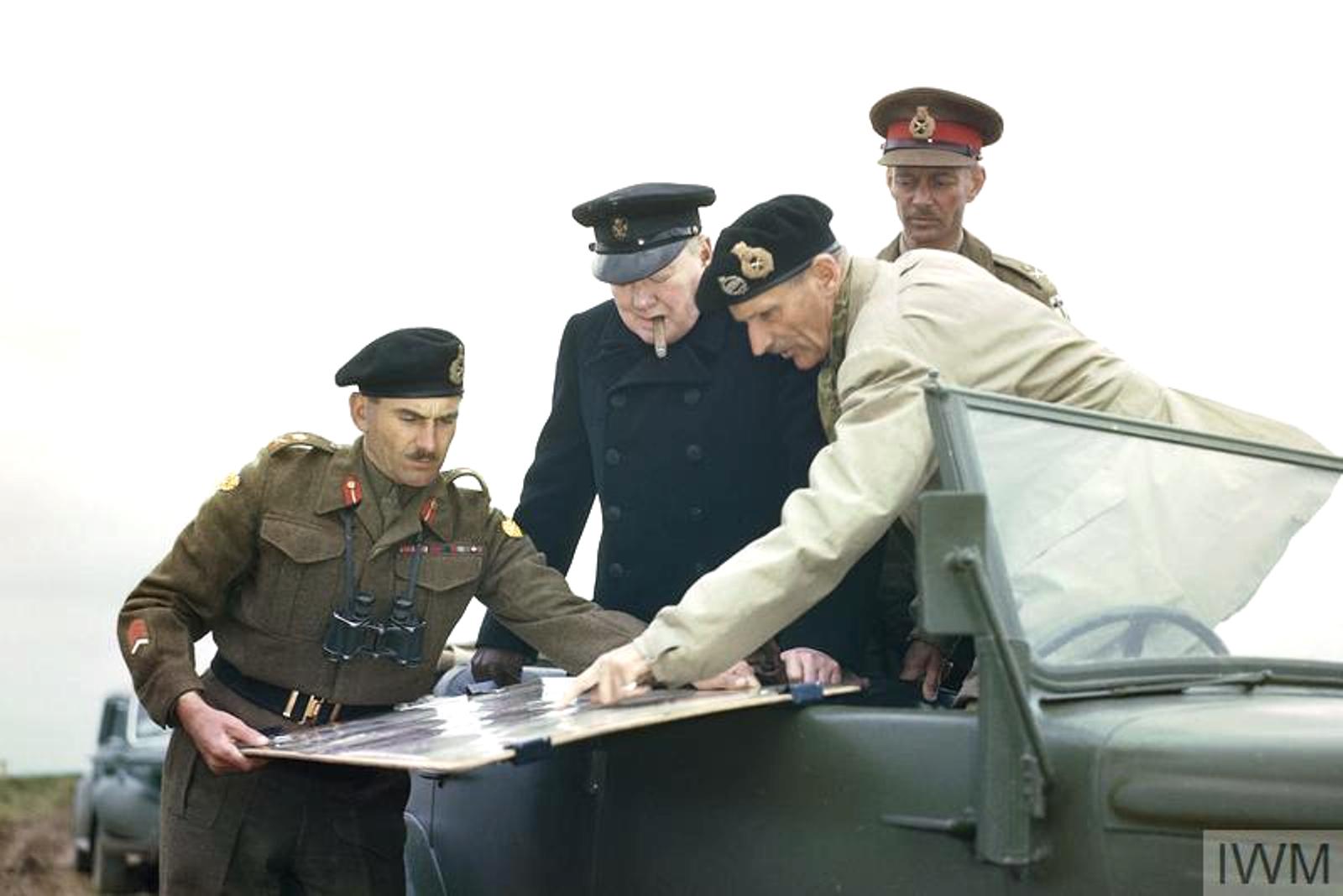 Bernard Montgomery showing Winston Churchill a map held by Gen GG Symonds, during Churchill's visit to Normandy, 22 Jul 1944. Behind Churchill is LGen Miles Dempsey.