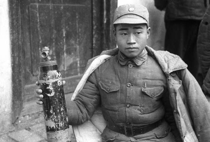 Chinese soldier displaying captured Japanese chemical weapon canister, Changde, Hunan Province, China, 17 Dec 1943