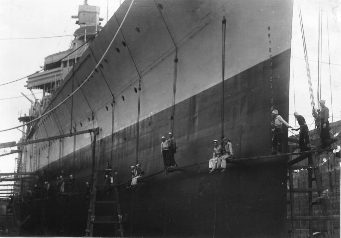 USS New Orleans in drydock at the New York Navy Yard with crew members scraping the hull, 1936. Good view of the bow section that got blown off seven years later in the Battle of Tassafaronga.