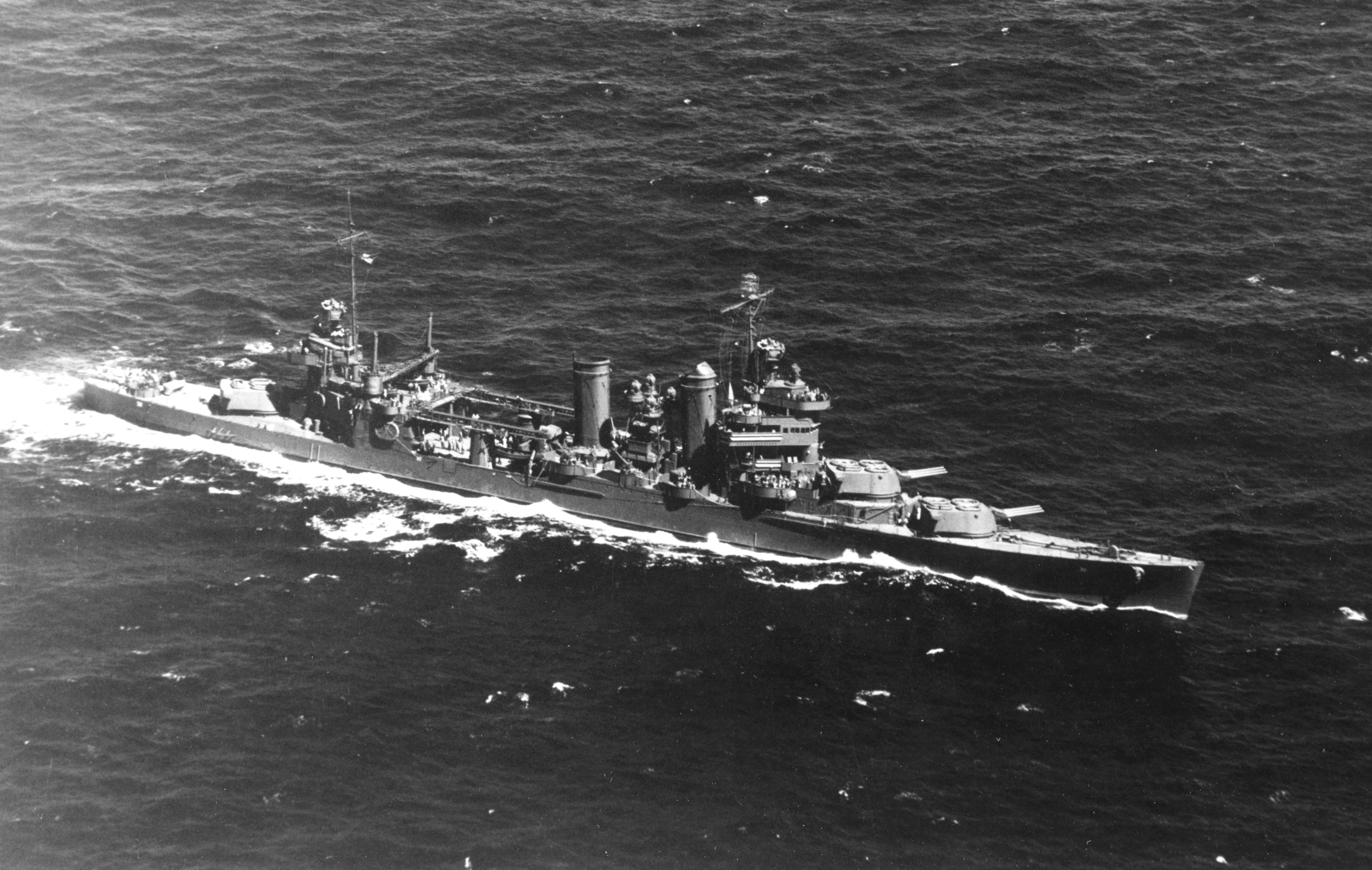 Aerial view of USS New Orleans during exercises in Hawaiian waters, 8 Jul 1942. Note all main guns trained to port.