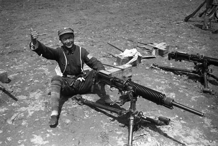 Chinese communist Eighth Route Army soldier posing with a captured Japanese machine gun, Yan'an, Shaanxi Province, China, 1944