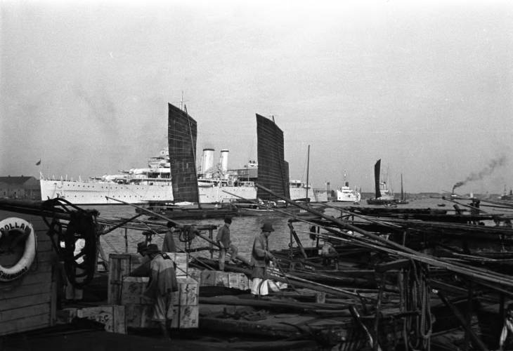 Chinese workers on a pier, Shanghai, China, mid-1937, photo 3 of 5; note HMS Cumberland in background
