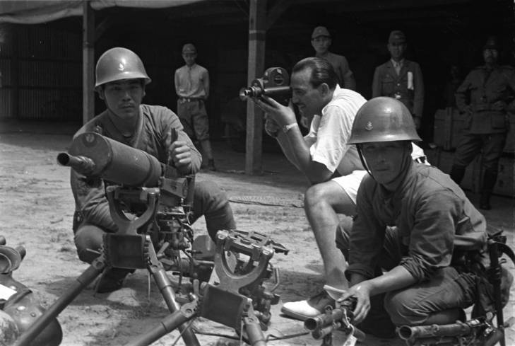 Harrison Forman filming Japanese naval infantrymen at Wusong, northern Shanghai, China, mid-1937; note captured Chinese Type 24 heavy machine gun and ZB vz. 26 machine guns