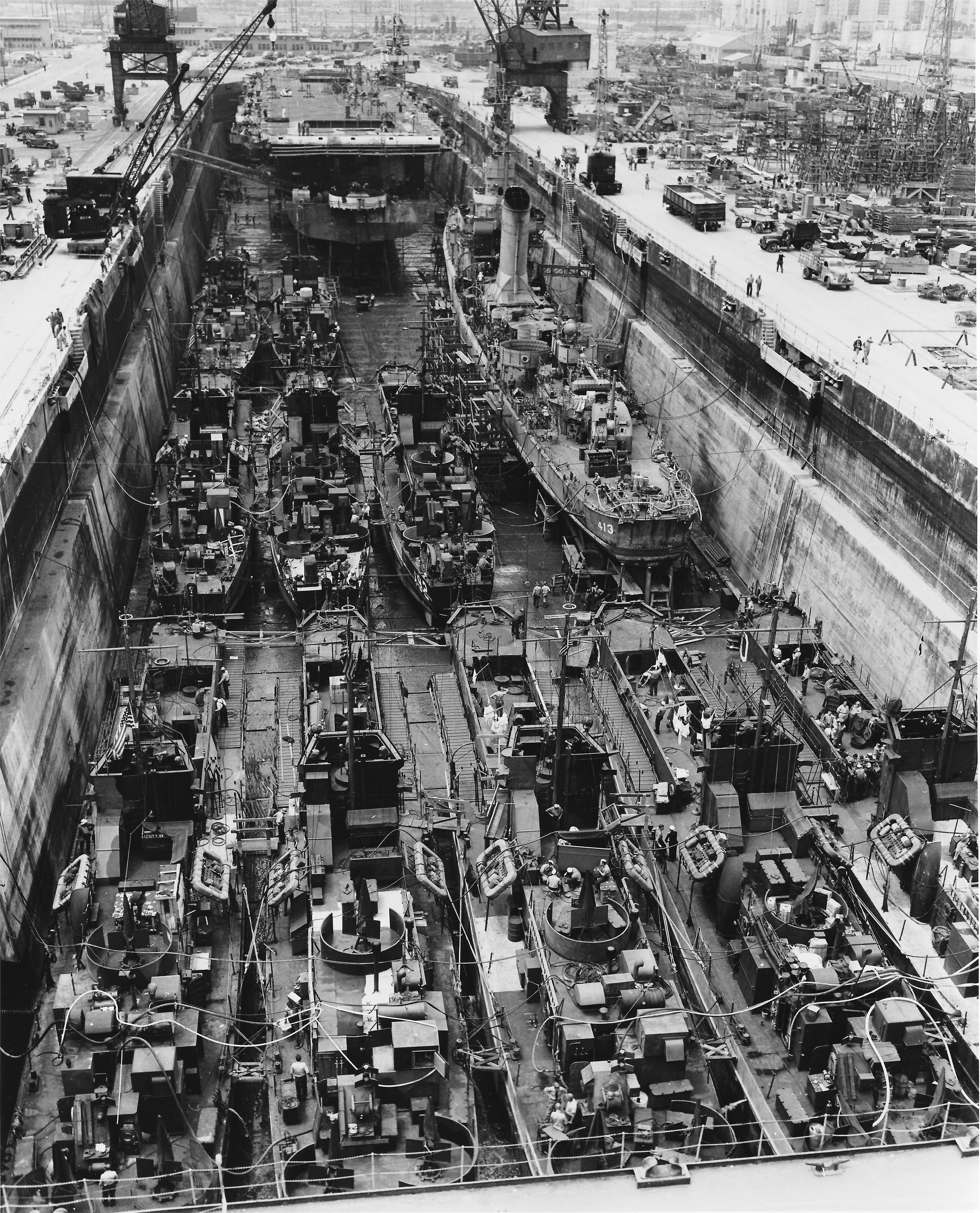 Drydock No. 1 at San Pedro, California, United States, one of the largest drydocks on the west coast, full of ships for upkeep, repair, and conversion, about 14 Jun 1945.