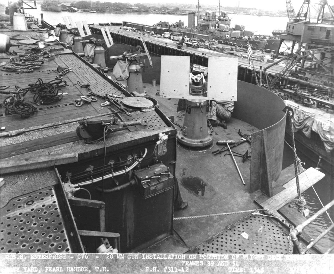 20mm gun gallery along the portside flight deck of USS Enterprise at Pearl Harbor, Hawaii, 19 Mar 1942. Note the guns are absent from the mounts. Note also destroyers USS Gridley and Fanning in the background.