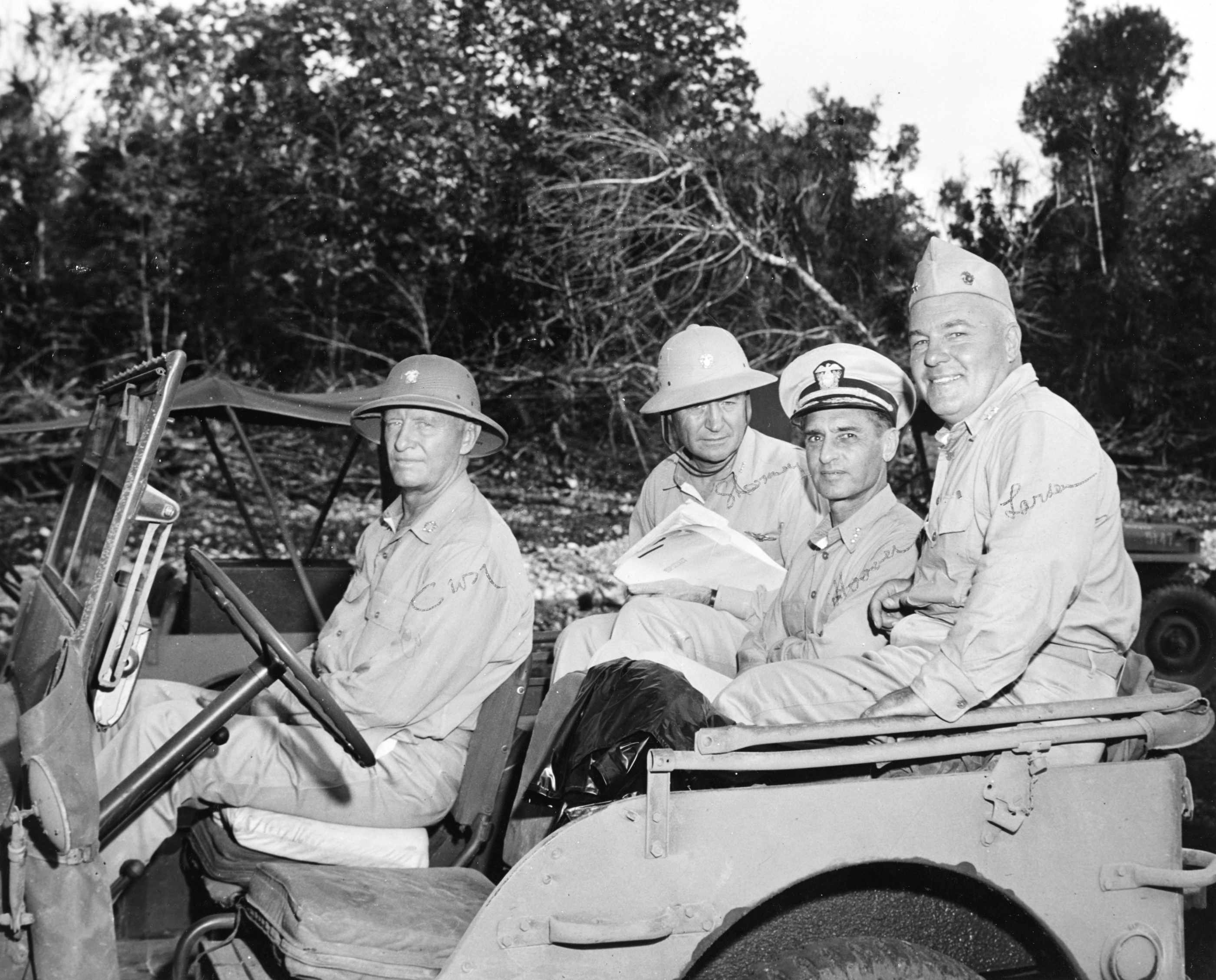Fleet Admiral Chester Nimitz and staff officers in a Jeep at Nimitz’ new forward headquarters on Guam, Mariana Islands, Apr-May 1945.