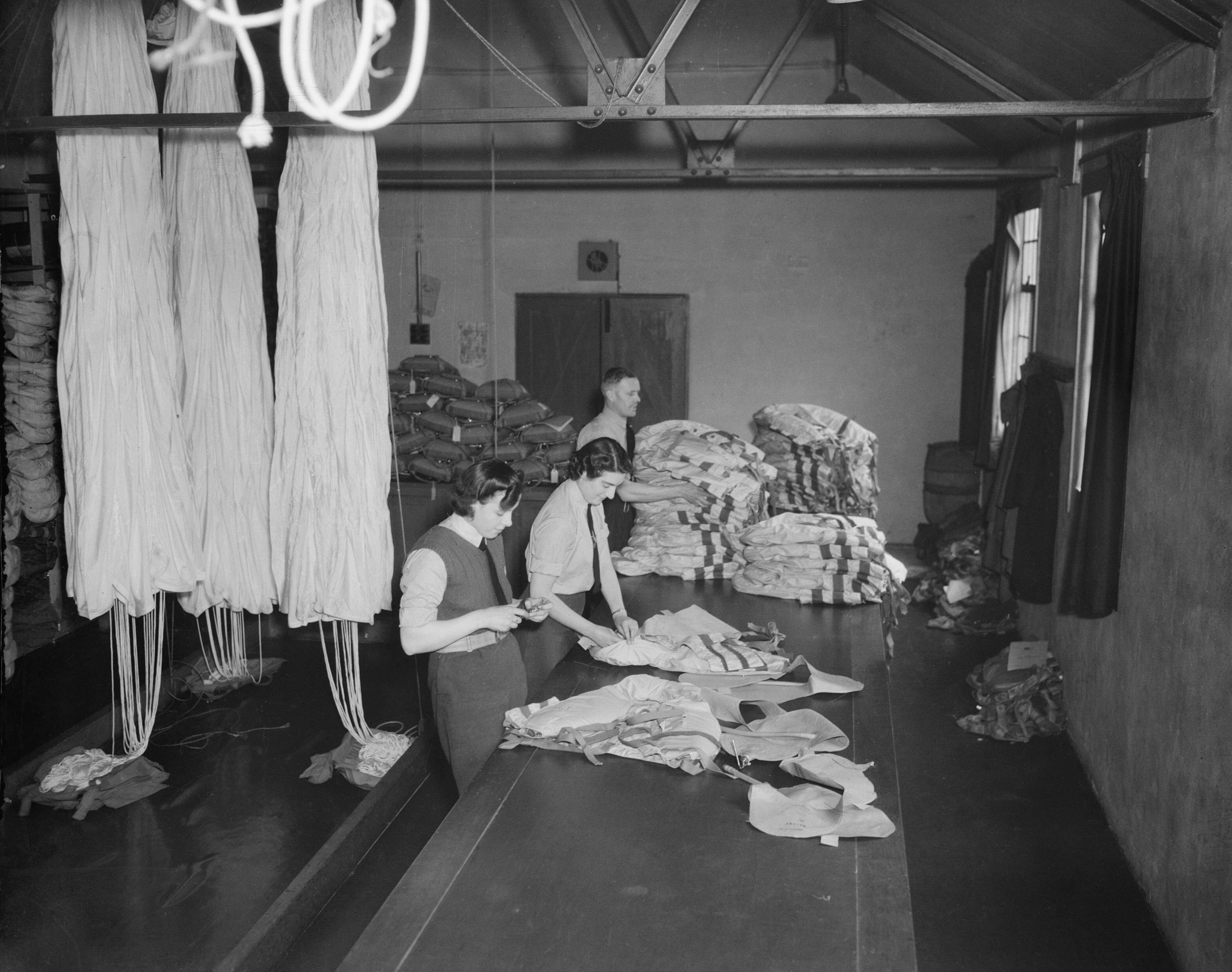 WAAF safety equipment assistants inspecting Mark I Life Jackets ('Mae Wests') in the parachute section at RAF Snaith, Yorkshire, England, United Kingdom, 1942-1945