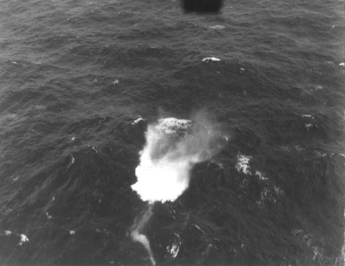 Photo showing a US Navy Mark 24 FIDO acoustic homing torpedo just entering the water. The torpedo can be seen beginning its track toward a submerged submarine. Mid-Atlantic, 12 Oct 1943.