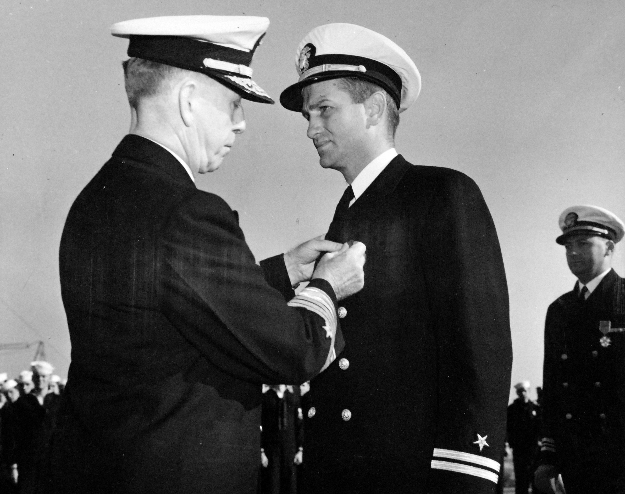 On the flight deck of USS Card, Admiral Royal E. Ingersoll, Commander-in-Chief Atlantic Fleet, awarding the Navy Cross to Lieutenant Charles Hutchins, Captain of USS Borie, for actions against German U-405.