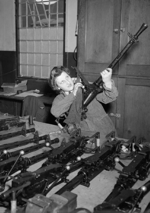WAAF Aircraftwoman Dorothy Roberts stripping and cleaning Browning machine guns at a glider training school, United Kingdom, 1942-1945