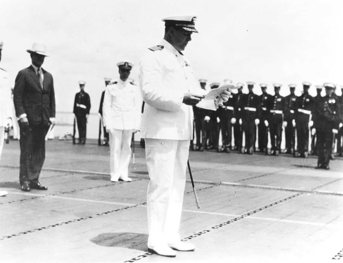 Captain Arthur L. Bristol reading his orders to take command of USS Ranger upon her commissioning at Norfolk, Virginia, 4 May 1934. Note the Marine detachment at the edge of the flight deck.