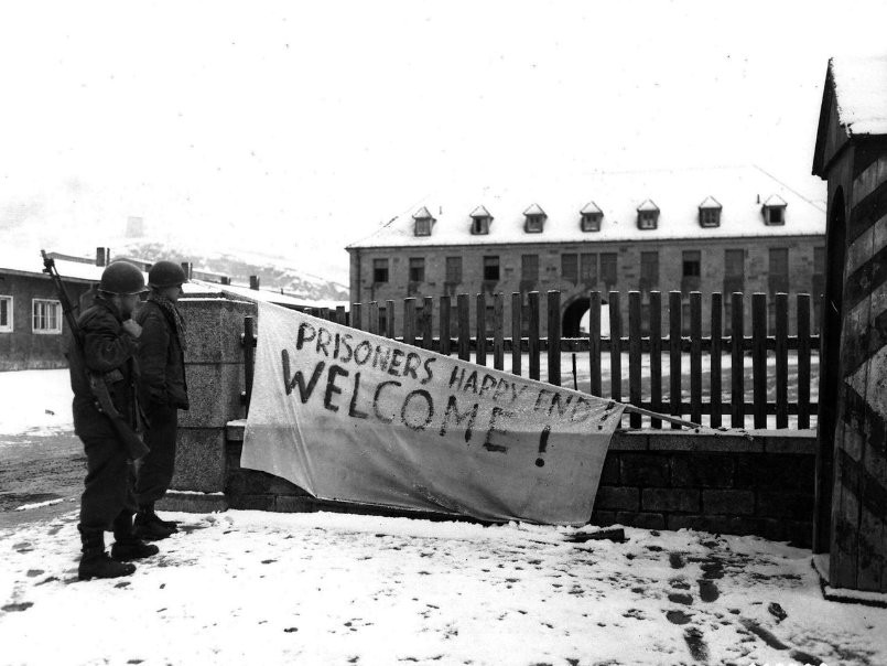 Two US soldiers looking at a sign made by prisoners of Flossenbürg Concentration Camp, Germany, 23 Apr 1945