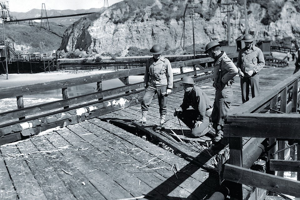 United States Army personnel inspecting damage to the Ellwood oil piers after Japanese submarine I-17 shelled the area on 23 Feb 1942, Goleta, California, United States.