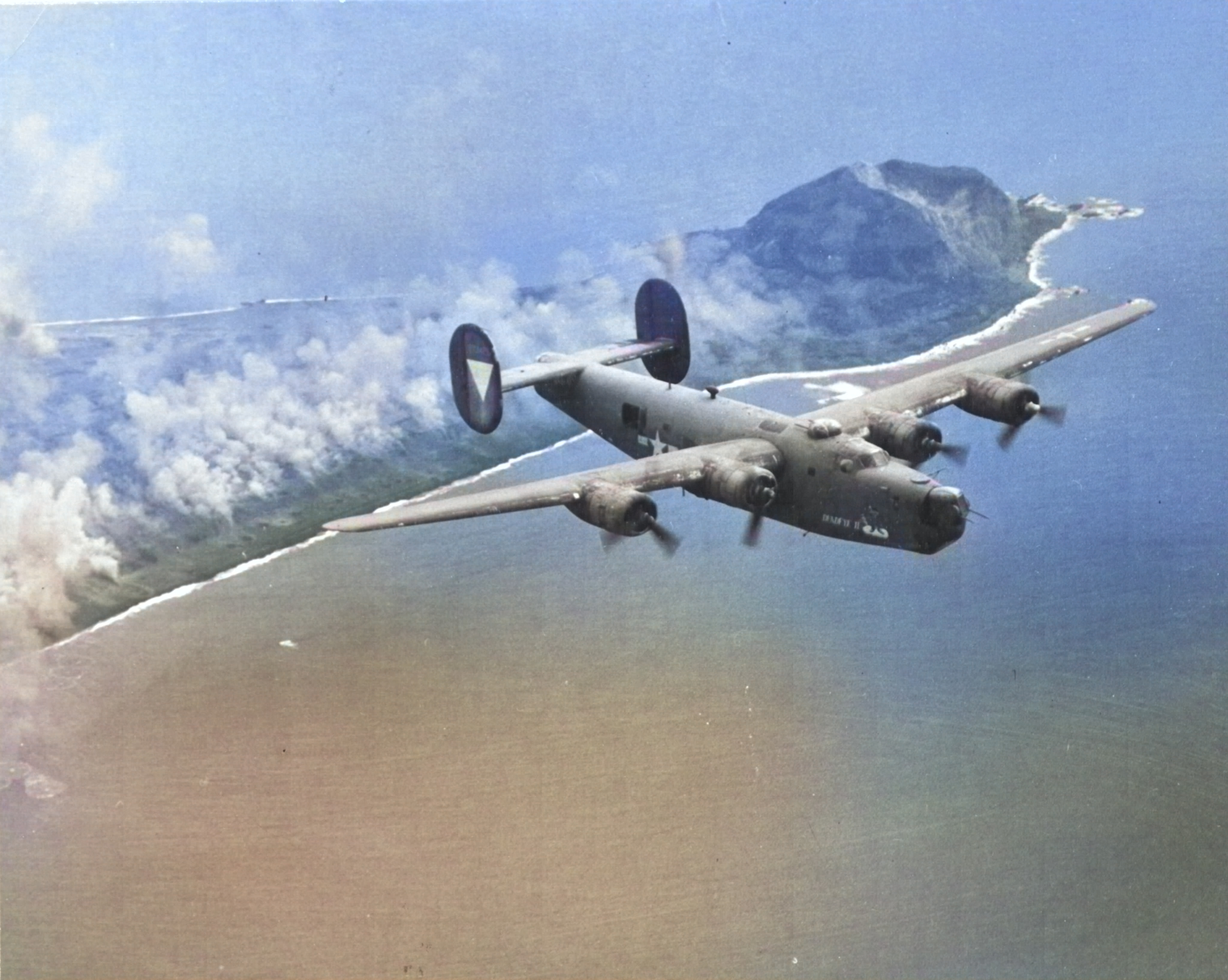 B-24J Liberator “Deadeye II” of the 392nd Bomb Squadron flown by Lt. Warren Myllenbeck flying from Saipan, Mariana Islands, overflying Iwo Jima and Mt Suribachi, 1944-45. [Colorized by WW2DB]